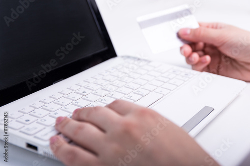 online shopping - female hands holding credit card and using lap