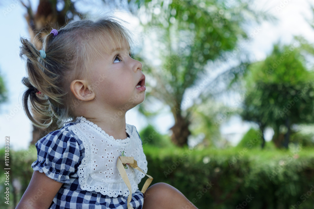 Cute little girl looking at the sky in summer day Cute little girl looking at the sky in summer day