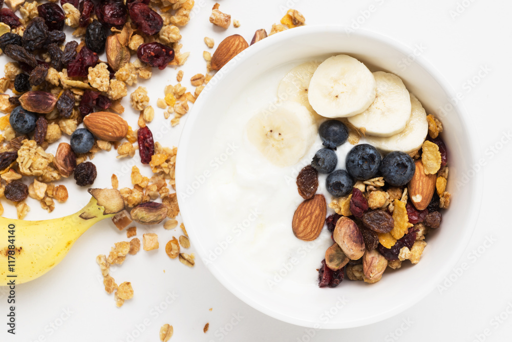 Fototapeta premium brunch : homemade yogurt with granola and banana in bowl on white table background. 