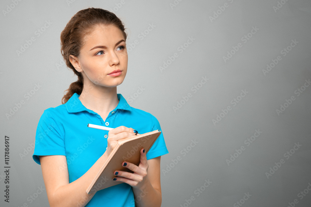 Pretty young beautiful woman standing, writing, take notes Pretty young beautiful woman standing, writing, take notes