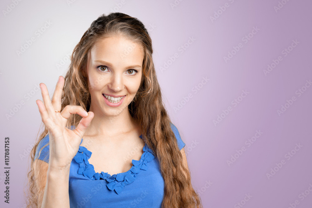 Beautiful young woman showing Ok sign