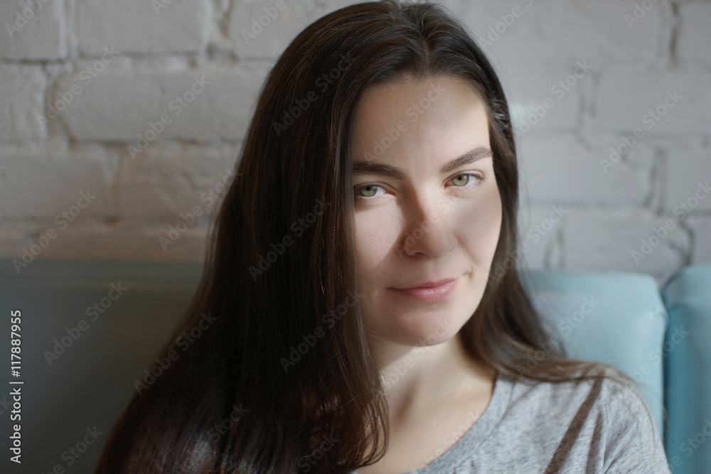 Young woman sitting in the cafe and the rays of the sun fall on her face. Young woman sitting in the cafe and the rays of the sun fall on her face.