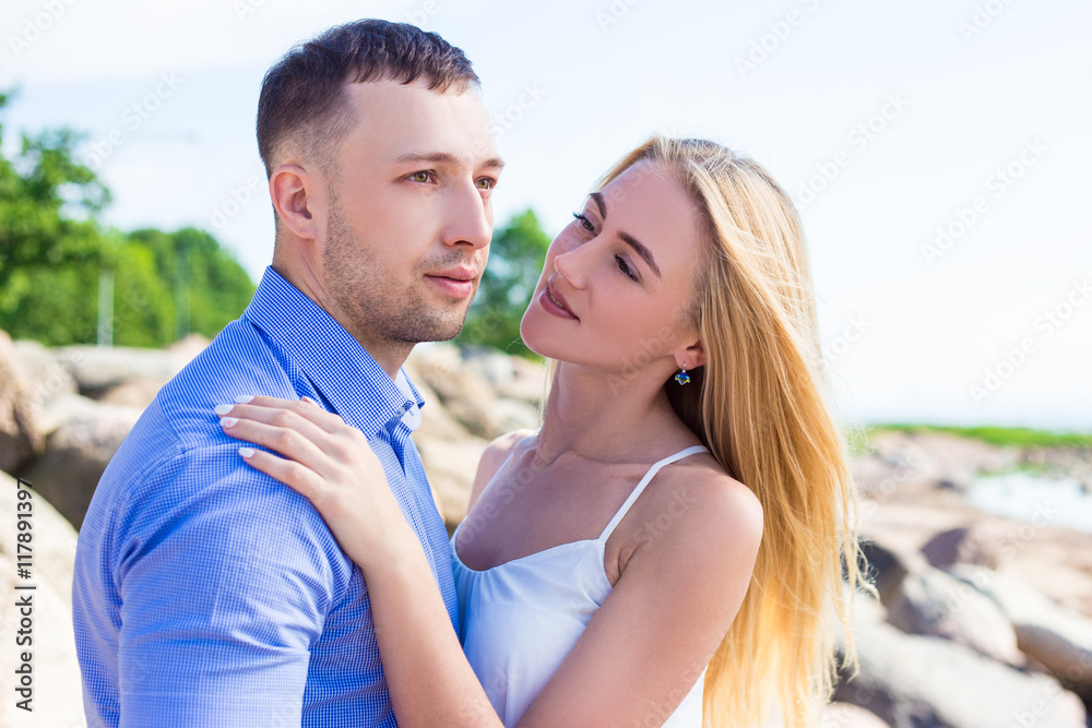 portrait of young beautiful couple posing on rocky beach portrait of young beautiful couple posing on rocky beach