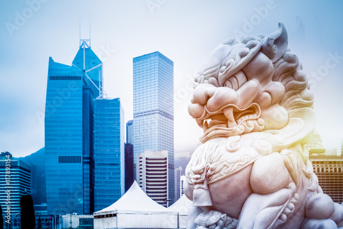 modern skyscrapers with a majestic stone lion in the foreground,hong kong,china.
