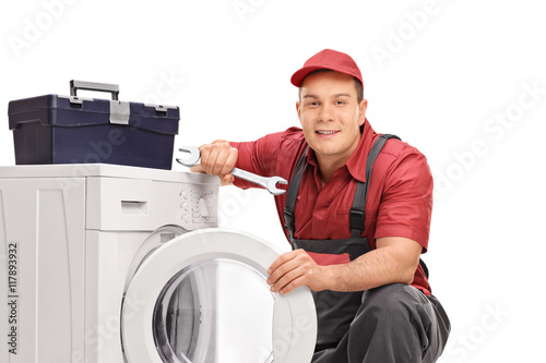 Repairman posing by a washing machine