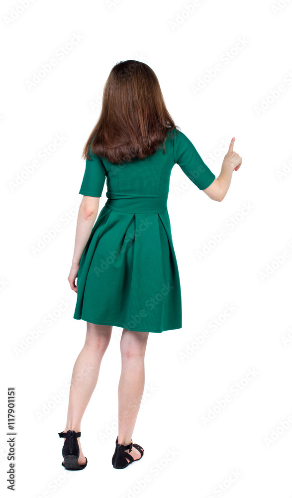 back view of woman. Young woman presses down on something. Isolated over white background. Rear view people collection. backside view of person. The slender brunette in a green short dress is calling back view of woman. Young woman presses down on something. Isolated over white background. Rear view people collection. backside view of person. The slender brunette in a green short dress is calling