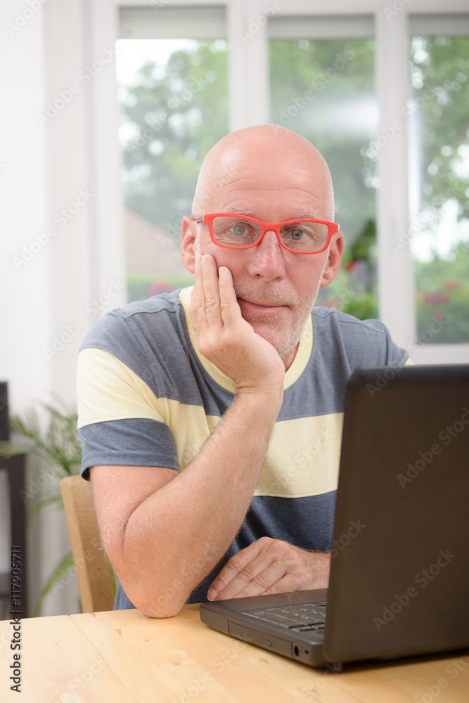 mature man with laptop in his home mature man with laptop in his home