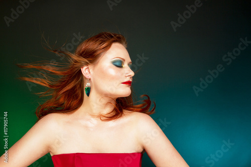 Рыжеволосая женщина с вечерним макияжем.
