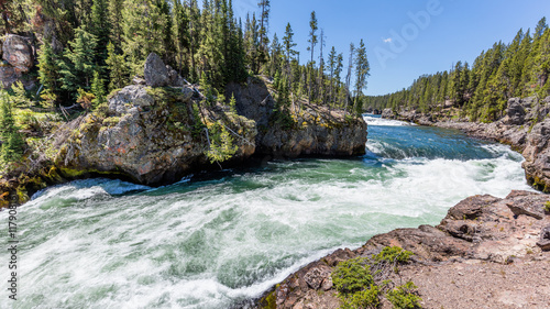 Fast flowing river on the background of the rocky coast. Brink of the upper falls, Grand Canyon of Yellowstone, Yellowstone National Park, Wyoming