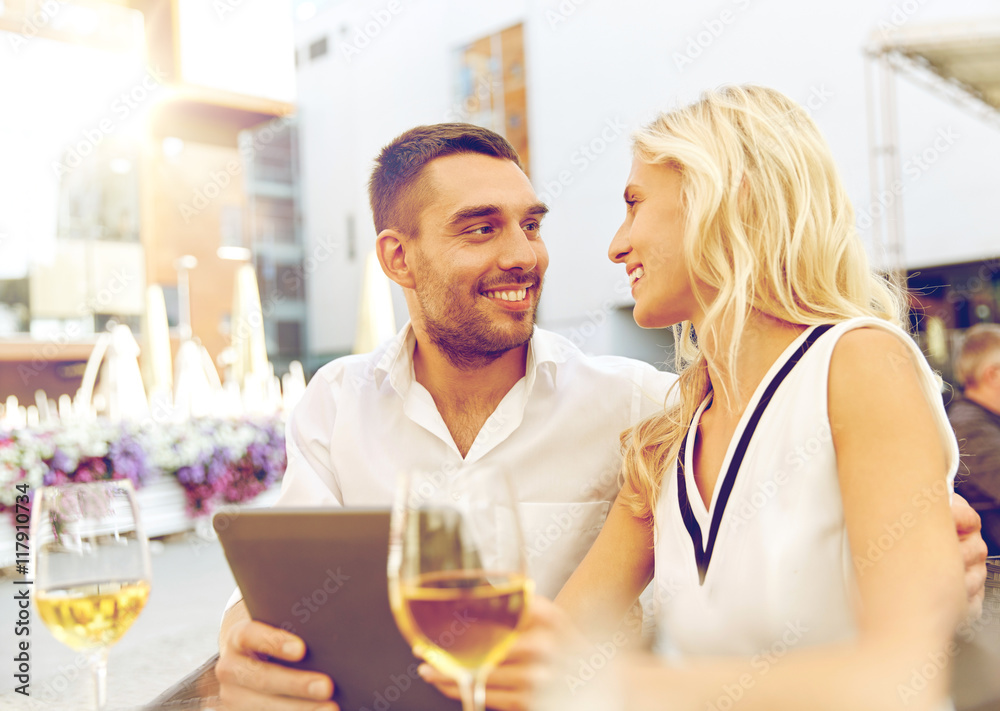happy couple with tablet pc at restaurant terrace happy couple with tablet pc at restaurant terrace
