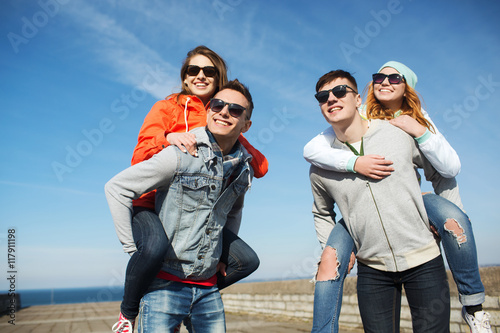 happy teenage friends in shades having fun outdoors