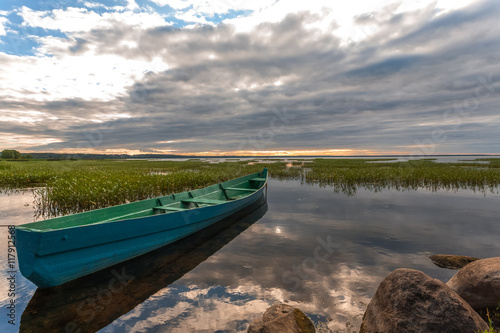 The fishing wooden boat at the coast before an evening storm.