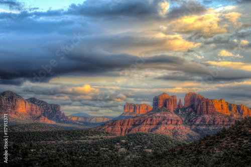Lat rays of sunlight on Cathedral Rock in Sedona Arizona with building storm clouds moving in.