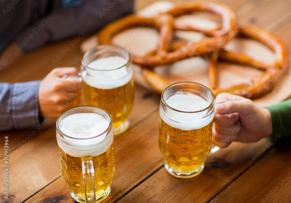 close up of hands with beer mugs at bar or pub close up of hands with beer mugs at bar or pub