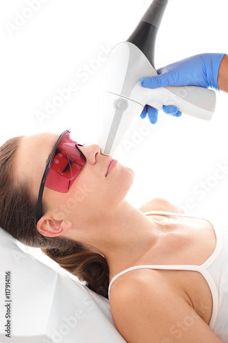 Kosmetyczka, depilacja laserowa. Klinika kosmetyczna, kobieta podczas zabiegu depilacji laserowej twarzy