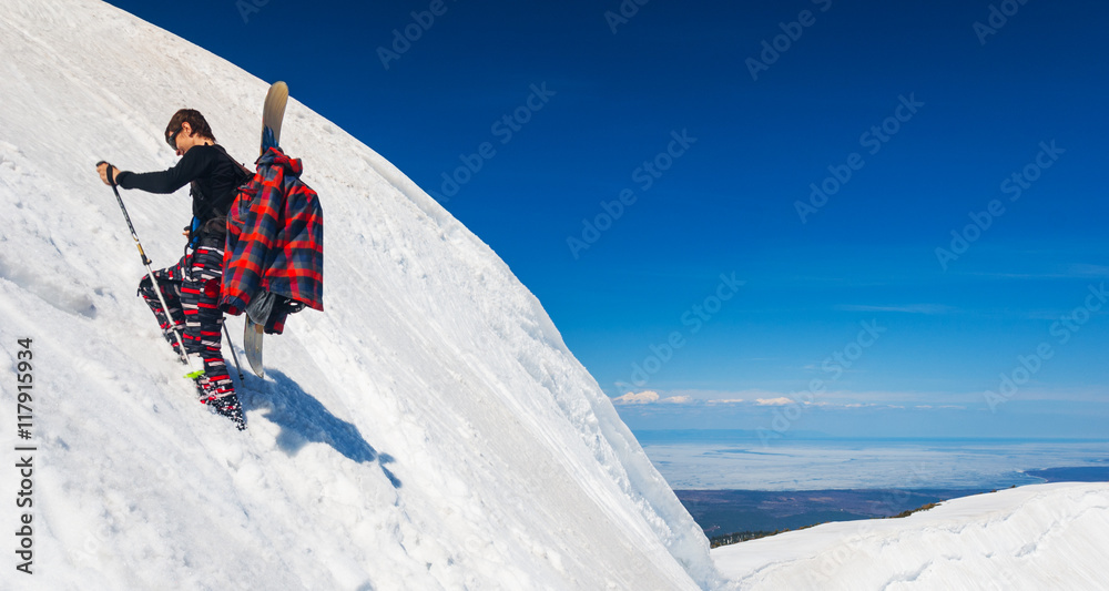 Young snowboarder climbing up the slope