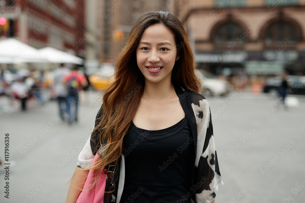 Young Asian woman in city walking smile happy face
