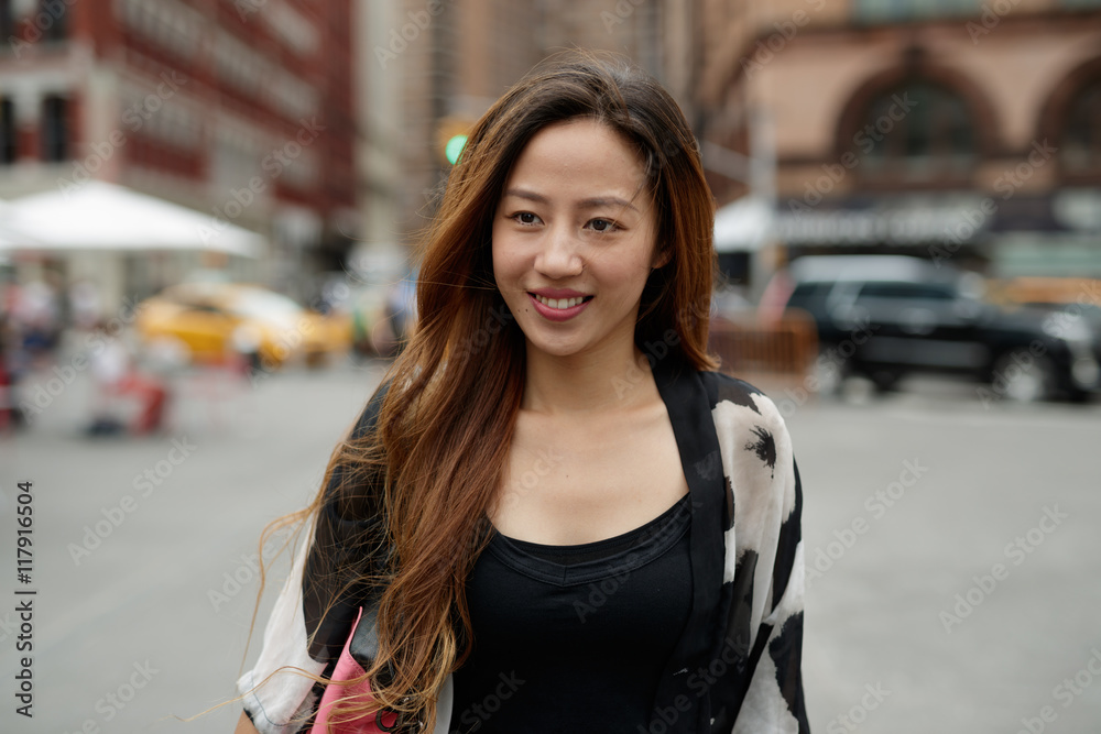 Fototapeta premium Young Asian woman in city walking smile happy face 