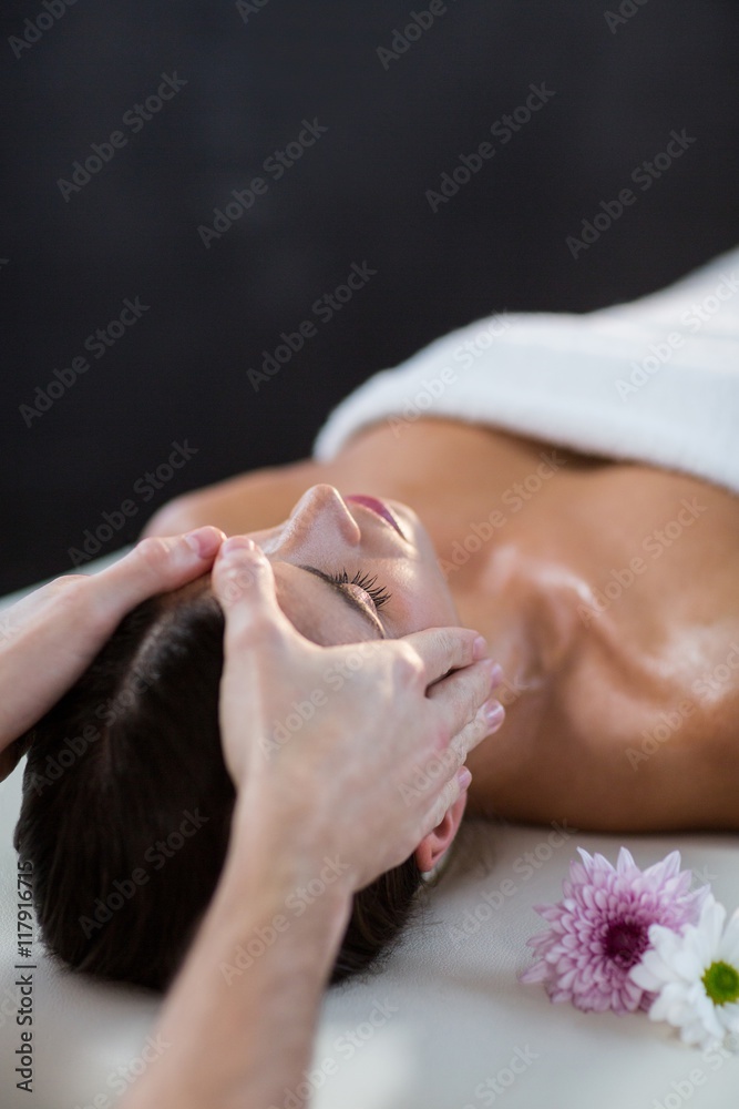Naklejka premium Male physiotherapist giving head massage to female patient
