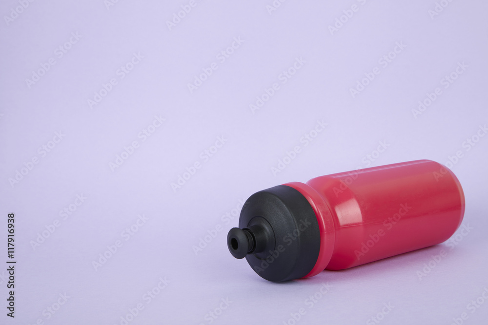A pink sports water bottle on a purple background forming a page border A pink sports water bottle on a purple background forming a page border