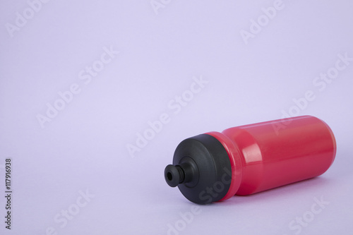 A pink sports water bottle on a purple background forming a page border