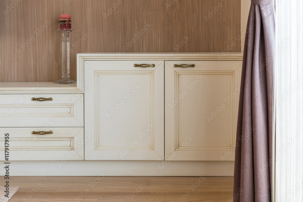 White wooden commode with tv unit near big window White wooden commode with tv unit near big window