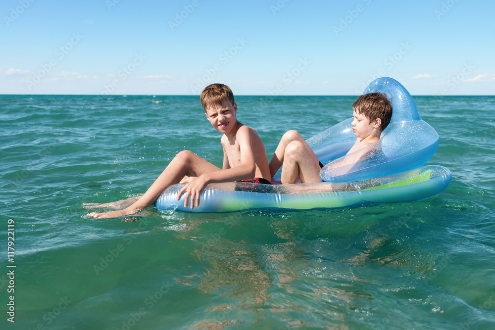 Two brothers swimming in inflatable boat