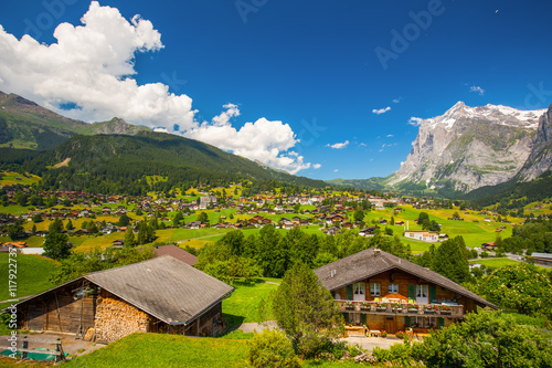 GRINDELWALD, SWITZERLAND - July 10, 2016 -View to famous Grindelwald valley, green forest, Alps chalets and Swiss Alps (Schreckhorn, Berglistock and Wetterhorn) in the background, Switzerland, Europe.