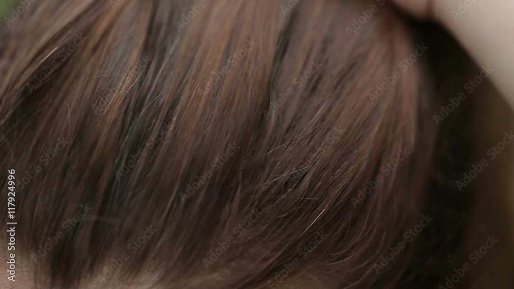 Close up view of a young girl straightens hair with her hand