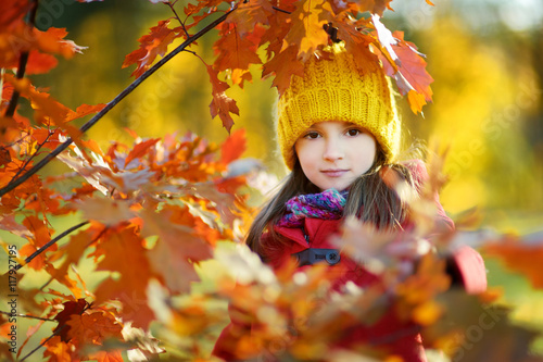 Cute little girl having fun on beautiful autumn day