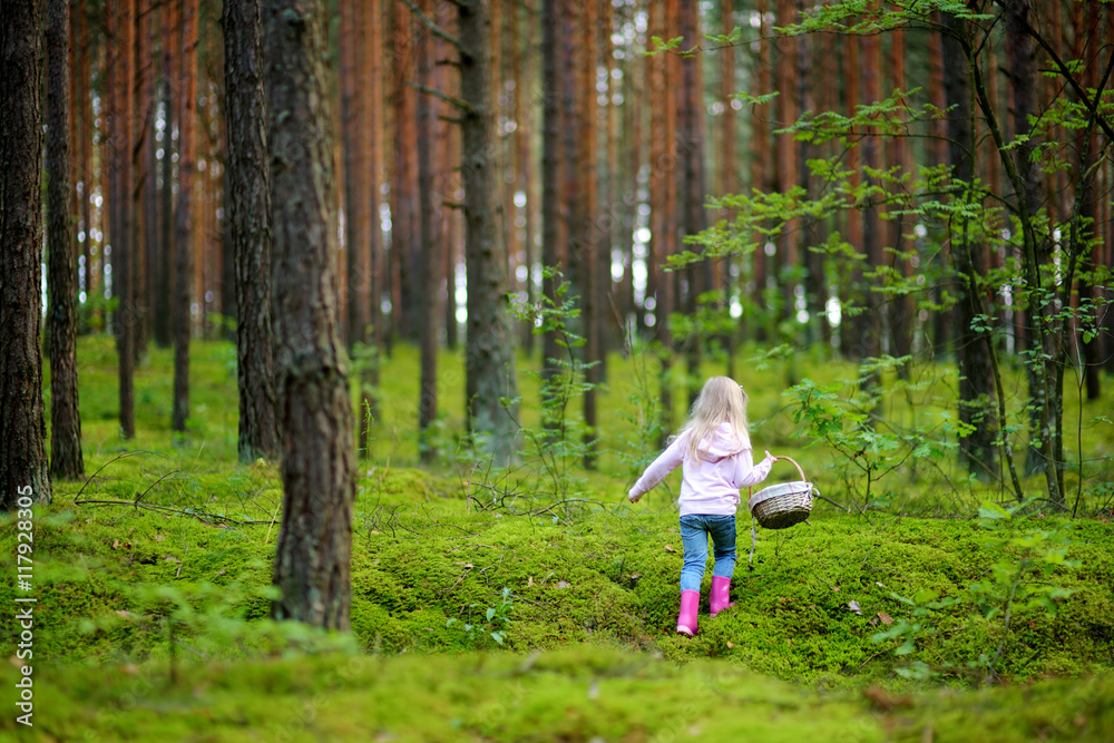 Adorable little girl picking foxberries in the forest Adorable little girl picking foxberries in the forest