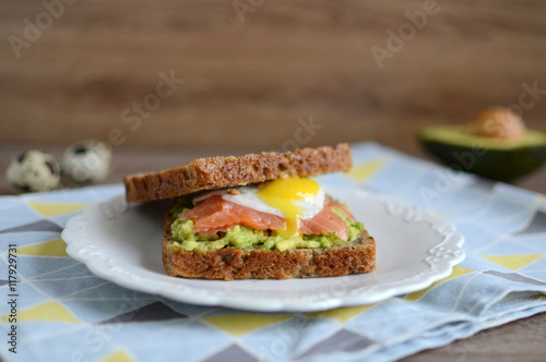 Sandwich with avocado, smoked salmon and quail egg