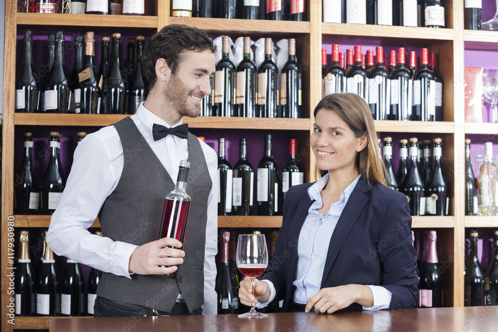 Customer And Bartender With Red Wine At Counter