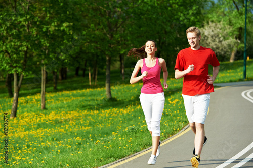 Young man and woman jogging outdoors