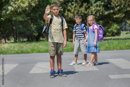 cute little school children students crossing street walking thr photo