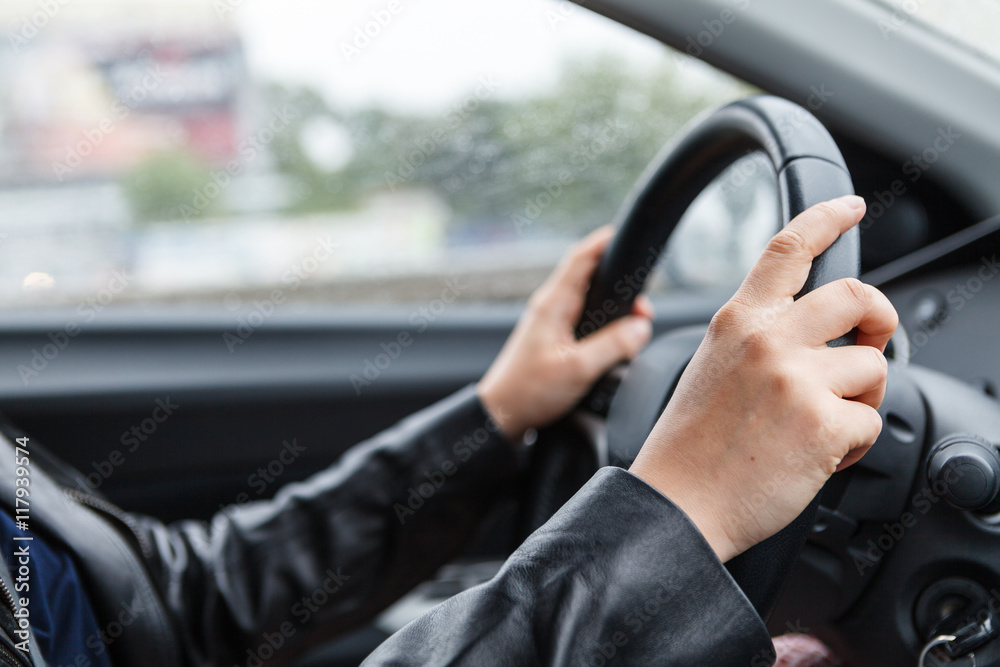 Driving a car, hands on steering wheel