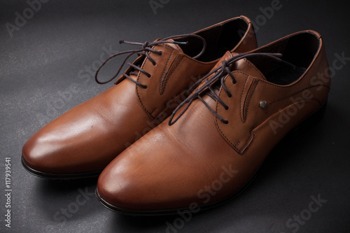 A Brown Classic Male Shoe on Solid Black Background