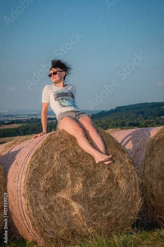 Femme sur une meule de foin dans un champs