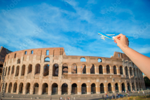 Closeup toy airplane on Colosseum background. Italian european vacation in Rome. Concept of travel imagination. photo