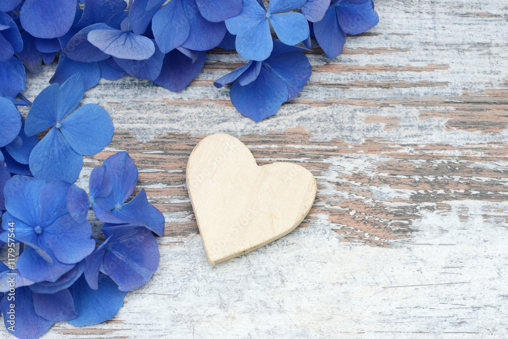 blue flower and wooden heart lying on wood blue flower and wooden heart lying on wood