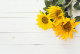 Background with a bouquet of sunflowers on a white painted woode