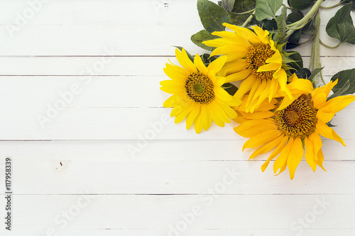 Background with a bouquet of sunflowers on a white painted woode