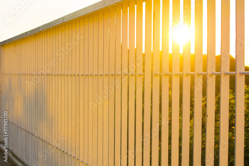 Sunset through the bars of the railing bridge beautiful background