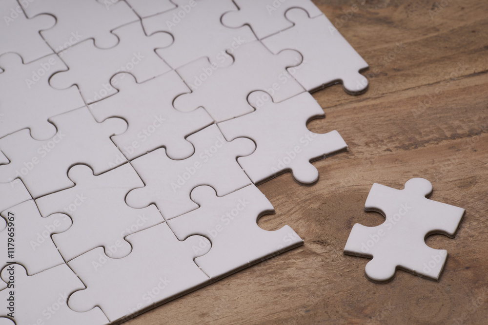 Fototapeta premium Incomplete puzzles on wooden table.