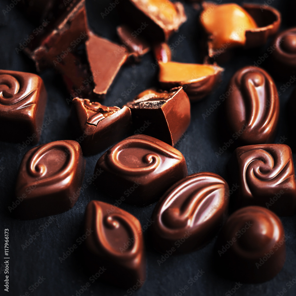 Dark chocolate background - chocolate candies on black table, to Dark chocolate background - chocolate candies on black table, to