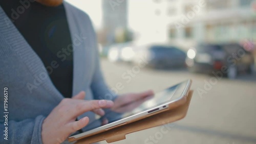 Close-up of the tablet which is held in hand by the man