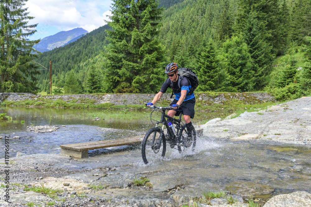 Fototapeta premium mit dem MTB einen Bach durchqueren