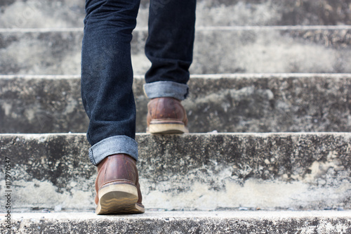 a man with blue geans and  sneaker shoes in stair