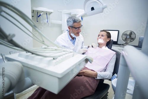Smiling dentist talking to patient