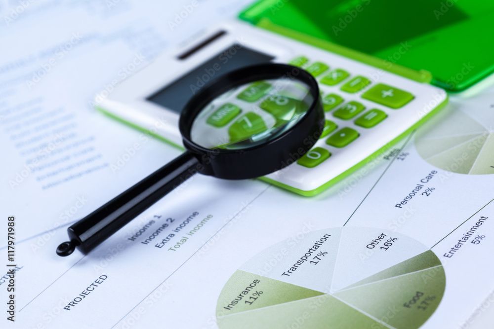 Calculator and magnifying glass on the table Calculator and magnifying glass on the table
